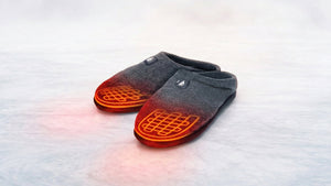 Grey heated slippers glowing red with warmth on a cool surface, promising cozy comfort for your feet.