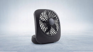 Sleek black TREVA portable battery-powered fan on a cool, light-toned surface, representing ultimate personal cooling.