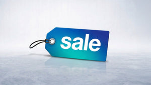 Blue and teal "Sale" price tag on a reflective surface, highlighting discounted items.