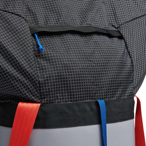 Pewter haul bag by Black Diamond with a white grid pattern, a top zipper with a blue pull, and vibrant red and blue webbing straps.