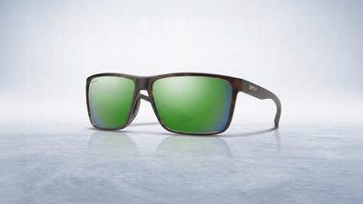 A pair of Smith sunglasses with dark tortoise-shell frames and bright green mirrored ChromaPop lenses, resting on a light textured surface.