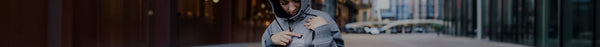 Person in a gray hoodie, looking down, points to 