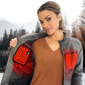 Red glowing heated jacket inserts by ActionHeat, shown within a woman's grey jacket in a forest.