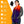Red to purple gradient heated fleece scarf by ActionHeat, featuring glowing yellow heating elements, front pockets, and a visible battery pack, worn by a smiling woman.