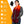 Red gradient fleece heated scarf by ActionHeat with glowing neck heating elements and front pockets, a battery pack visible.