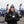 Men's black softshell battery heated jacket by ActionHeat, with a Denver Broncos logo, worn by a man holding a steaming coffee cup outdoors.