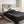 Dark gray microlight heated blanket by Beautyrest covering a king bed, with a woman holding a white mug.