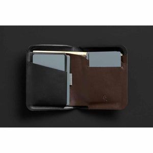 Open black and brown leather Apex Note Sleeve by Bellroy with gray cards in slots and an owl logo.