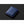 Blue smooth material note sleeve by Bellroy, closed, with a subtle debossed logo and red trim along the bottom edge, on a dark background.