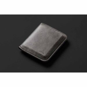 Dark gray bifold wallet by Bellroy with a fine textured finish and debossed logo, angled view.