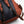 Rust-colored daypack by Bellroy, showing a dark grey mesh back panel and adjustable black straps with brown webbing.