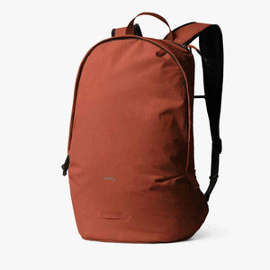 Rust-colored lightweight daypack by Bellroy with a minimalist design and black shoulder straps.