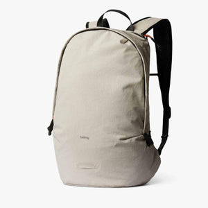 Light beige lightweight daypack by Bellroy featuring black straps, orange accents, and a subtle woven texture.