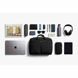 Black work bag by Bellroy with top handles and a front pocket, surrounded by daily essentials.
