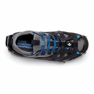 Black and silver spike traction device by Black Diamond, with blue accents, on a grey hiking shoe, top-down view.
