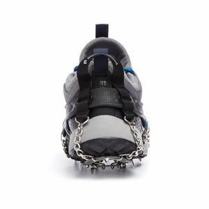 Silver spike traction device by Black Diamond with a black harness, shown on the back heel of a gray running shoe.