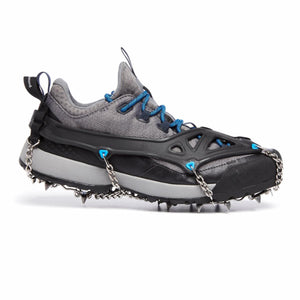 Black spike traction device by Black Diamond, featuring silver chains and sharp metal spikes attached to a grey trail running shoe.