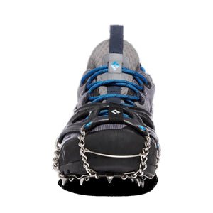 Black and silver spike traction device by Black Diamond, worn on a gray and blue trail shoe, front view.