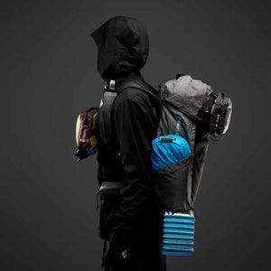 Grey ultralight Beta Light 30 Backpack by Black Diamond, worn by a person, with blue gear in mesh pockets.
