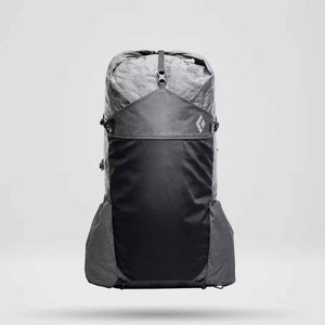 Light grey and black hiking backpack by Black Diamond featuring a crinkled roll-top, dark grey grid pattern, and white logo.