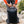 Black and gray grid pattern backpack by Black Diamond, being fastened by hands in an outdoor setting.