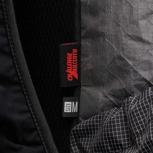 Black backpack by Black Diamond with a 'CHALLENGE SAILCLOTH' label, a 'SIZE M' tag, and textured black fabrics.
