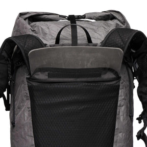 Gray grid-pattern backpack by Black Diamond with a roll-top closure, visible foam back panel, and black mesh front pocket.