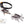 Silver metal strap crampons with black webbing and an orange adjustment knob by Black Diamond, shown angled to display spikes and adjustable length.