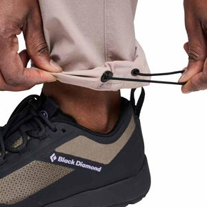 Light tan Women's Alpine Light Pant by Black Diamond with adjustable drawstring cuffs, worn with a black and tan shoe.