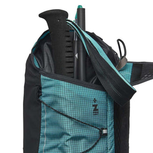 Teal grid-patterned backpack by Black Diamond, with 'Z POLE CARRY' logo, holding trekking poles in a side pocket.