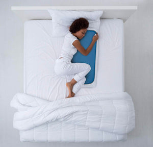 Blue cooling pad by Cool Care Technologies on a white bed with a woman sleeping.