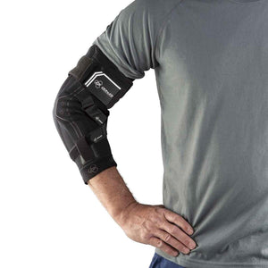 Black elbow brace by DonJoy, worn by a man in a gray t-shirt, showing the side with white logos and straps.