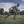 Black orthopedic knee brace by DonJoy securing a man's right knee as he sprints on a green field.