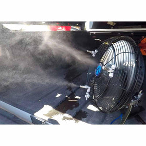 Black portable misting fan by ExtremeMIST with multiple nozzles spraying a fine mist in a truck bed.