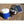 Black portable misting fan by ExtremeMIST with white blades, connected to a blue water tank and solar panel, on outdoor pavers.