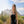 Black personal mister by ExtremeMIST spraying a fine mist, carried by a woman in a desert landscape.