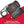 Black 12V to USB charger by Gerbing connected to a smartphone showing 66% battery, on a red and white surface.