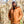 Men's rust brown heated workwear jacket by Gobi Heat, with a hood and multiple zippered pockets, worn by a bearded man in a forest.
