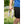 White neck cooling fan by Gobi Heat, held by a person in a blue shirt and black shorts, outdoors.
