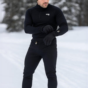 Black Men's FlexCore Heated Base Layer Pant by Gobi Heat with visible dual control buttons, worn outdoors in snow.