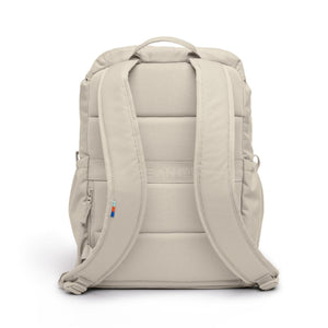 Beige Flap Pack Bag by Got Bag, back view with padded mesh panel, shoulder straps, and a small colorful tag.