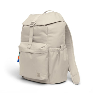 Light beige fabric Flap Pack Bag by Got Bag in 3/4 view, featuring a flap with buckle, front pocket, side pocket, and colorful zipper pull.