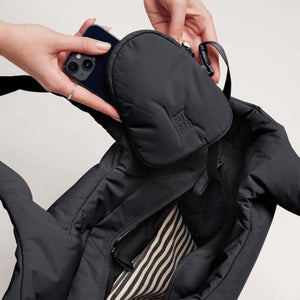 Black padded tote bag by Got Bag with a removable pouch, a phone being placed inside, and striped lining.