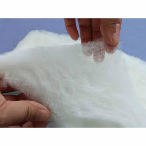 White, fluffy silk comforter filling by HealthyLine, held by hands showing its soft texture.