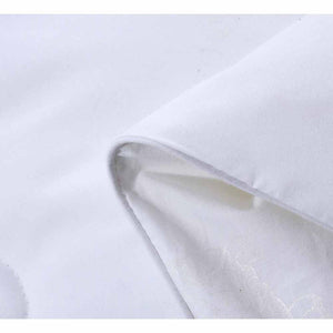 White silk comforter by HealthyLine with a folded corner revealing a subtle patterned inner lining and grey piping.