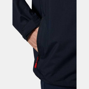 Dark blue men's midlayer jacket by Helly Hansen, side view, showing a hand in its zippered pocket with a red pull and an adjustable cuff.