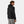 Black hooded insulator jacket from Helly Hansen, shown from the back-right side on a man wearing grey pants.