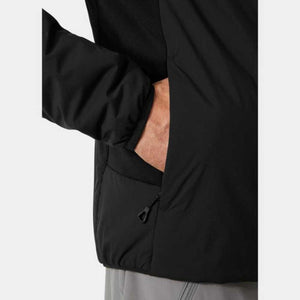 Black insulated jacket by Helly Hansen, cropped view with a hand in a zippered side pocket and black pull tab.