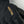 Black five-finger glove by Hestra with a gold embroidered logo and contrasting yellow stitching on the leather palm.