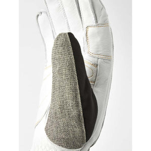 White leather glove by Hestra, with a textured grey-brown patch and black stripe along the thumb.